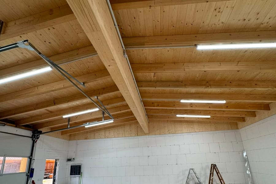 Sichtbare Holzdachkonstruktion mit Balkenlage und Nadelholzschalung